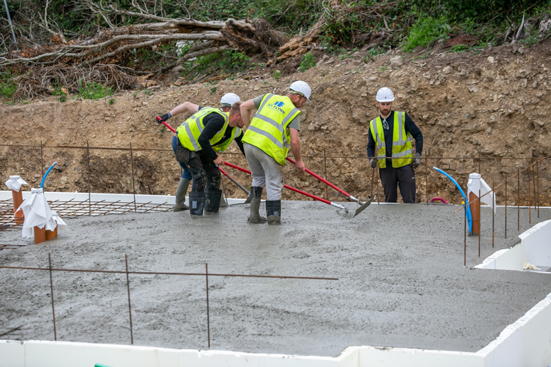 Workers spreading concrete across a KORE Insulated Foundation System